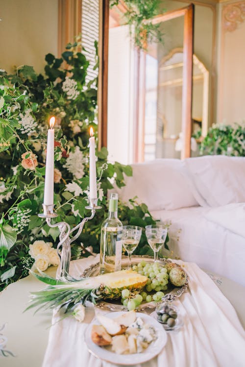 White Lighted Candles  Beside Wine Bottle and Wine Glasses on Silver Tray with Fruits