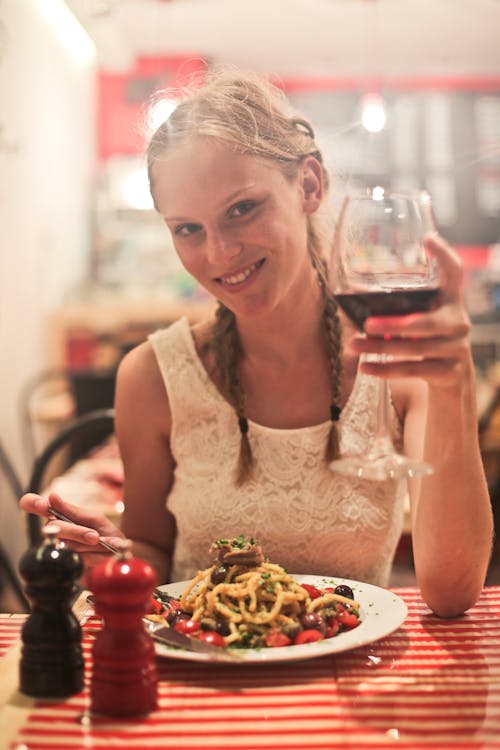 Femme En Hauts Sans Manches Blanc Tenant Un Verre à Vin