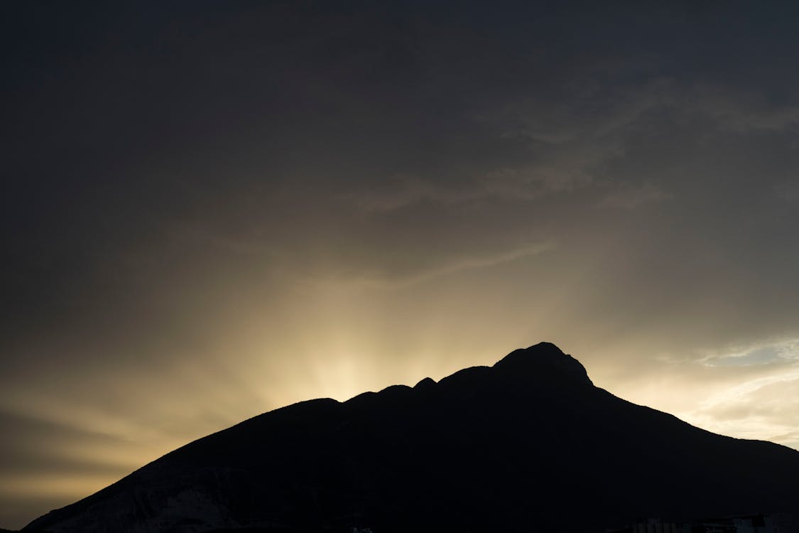 Silhouette of Mountain Under Dark Cloudy Sky