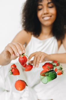 Creative image of a woman gracefully interacting with floating strawberries.