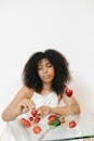 Woman in White Tank Top Holding Red Lollipop