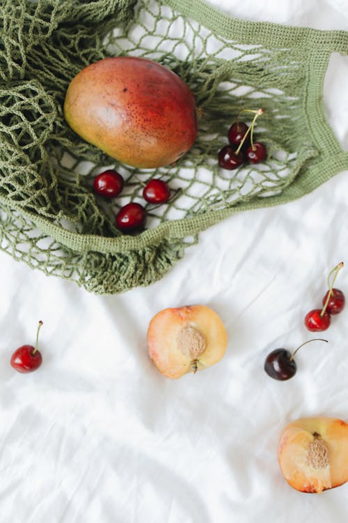 Net Bag and Fruits on White Textile