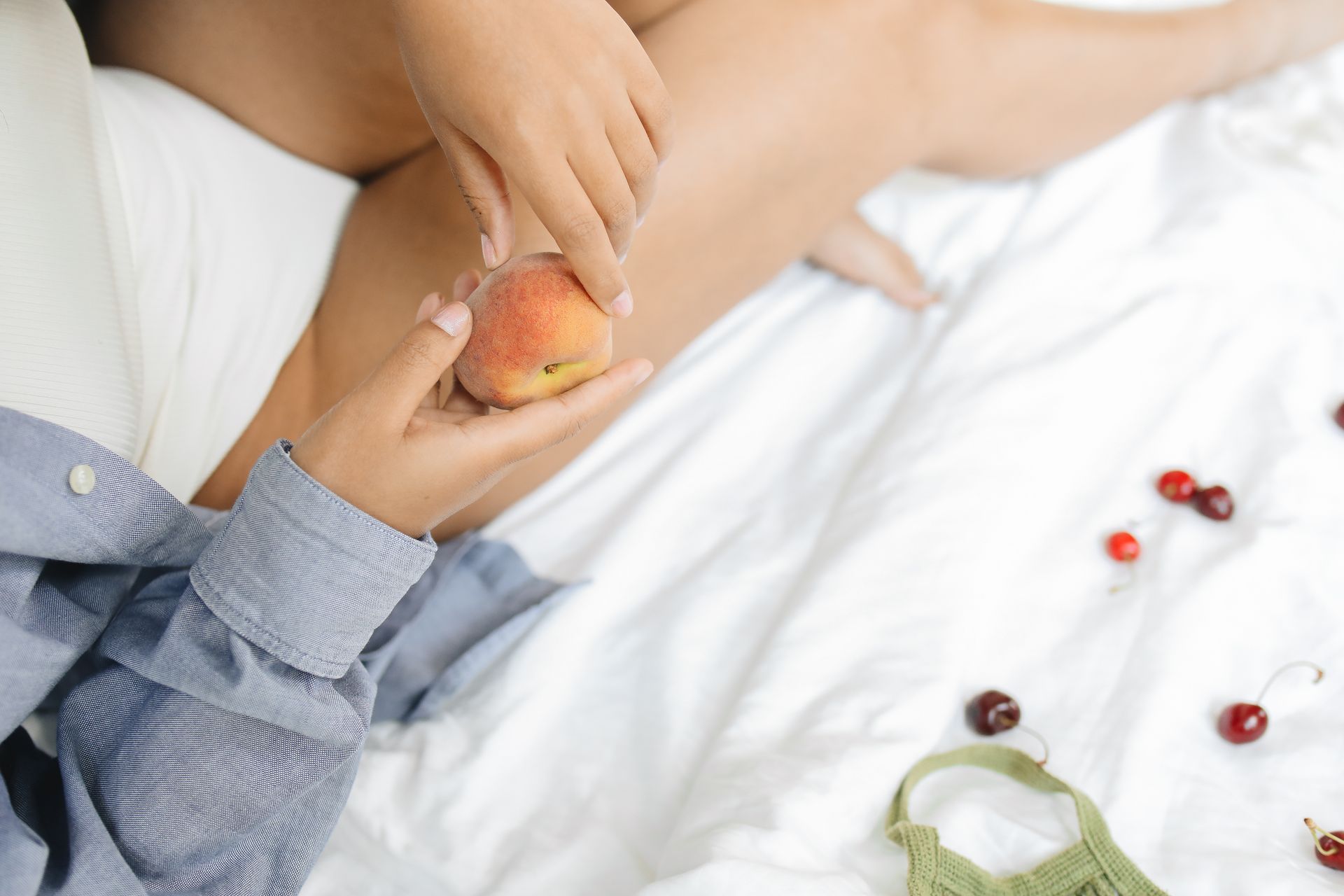 A Person Wearing a Blue Denim Long Sleeves Holding a Peach
