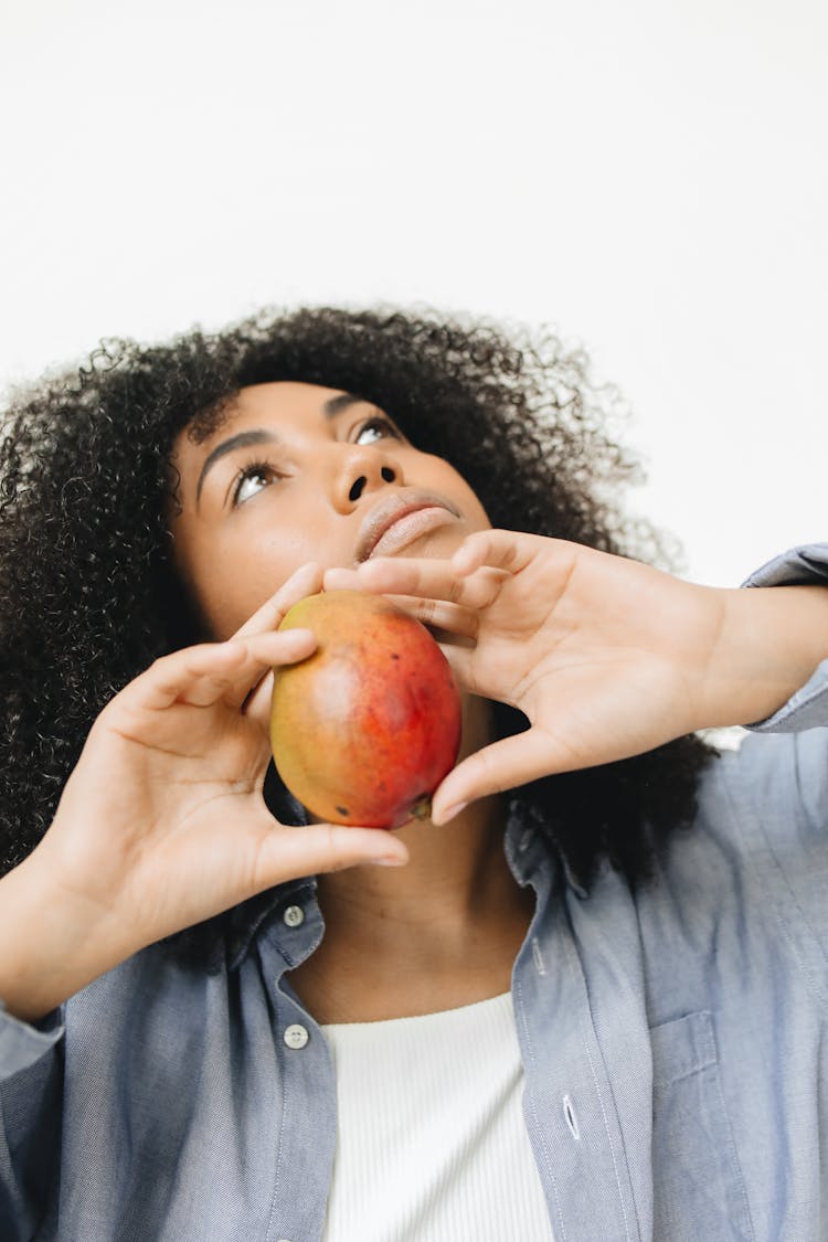 A Woman Holding A Mango