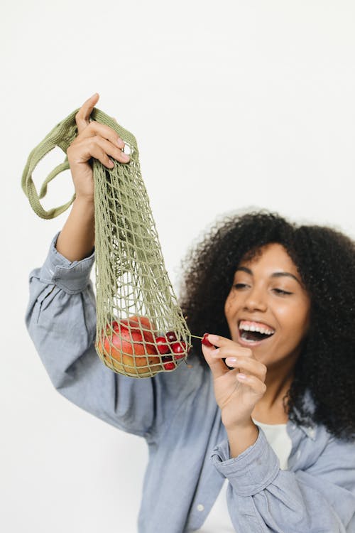 A Woman Getting a Cherry from the Mesh Bag