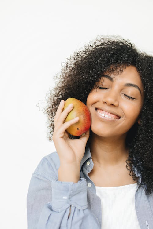 A Happy Woman Holding a Mango