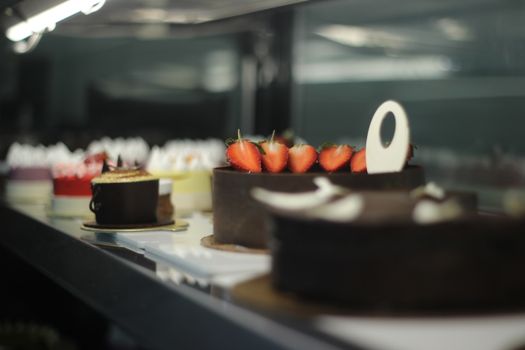 Assorted cakes displayed beautifully in a stylish cafe, offering a delightful and sweet indulgence.