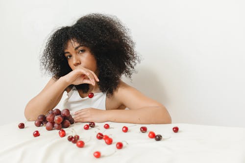 Woman in White Tank Top Holding a Cherry