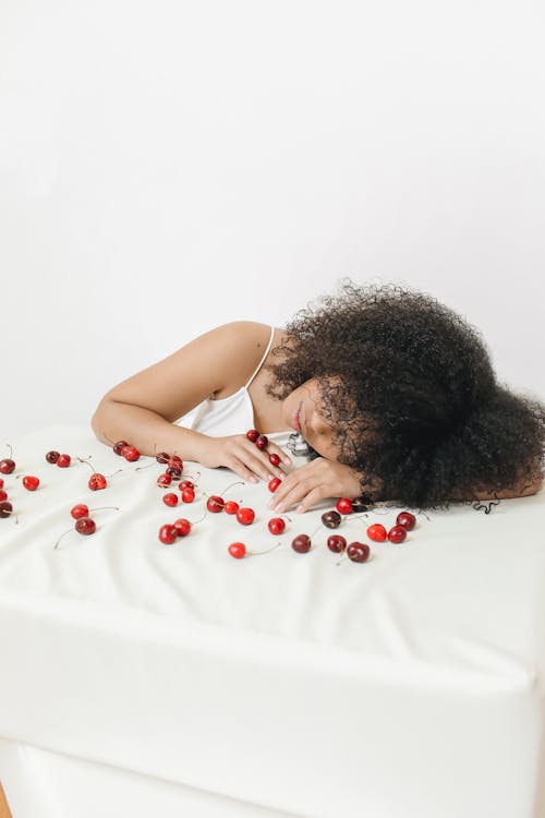 Woman Resting Her Head on a Table with Cherries 