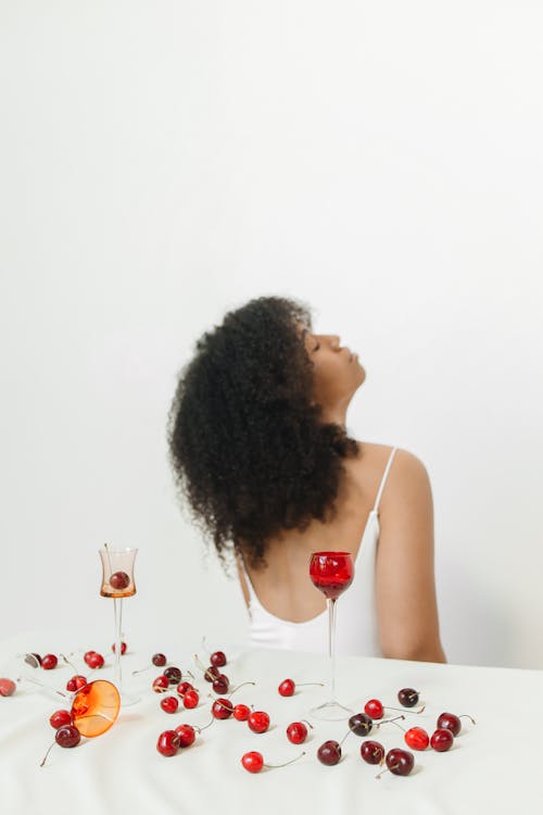 Woman Behind a Table with Cherries and Wineglasses