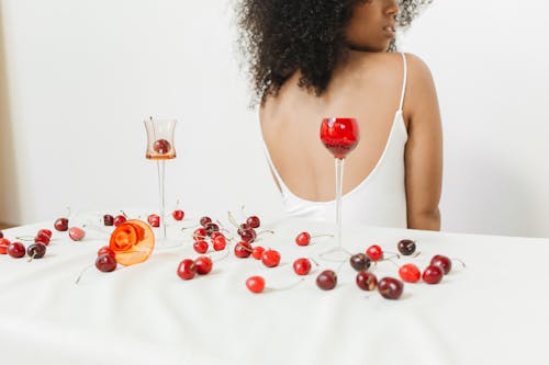 Woman Near White Table with Scattered Cherries 
