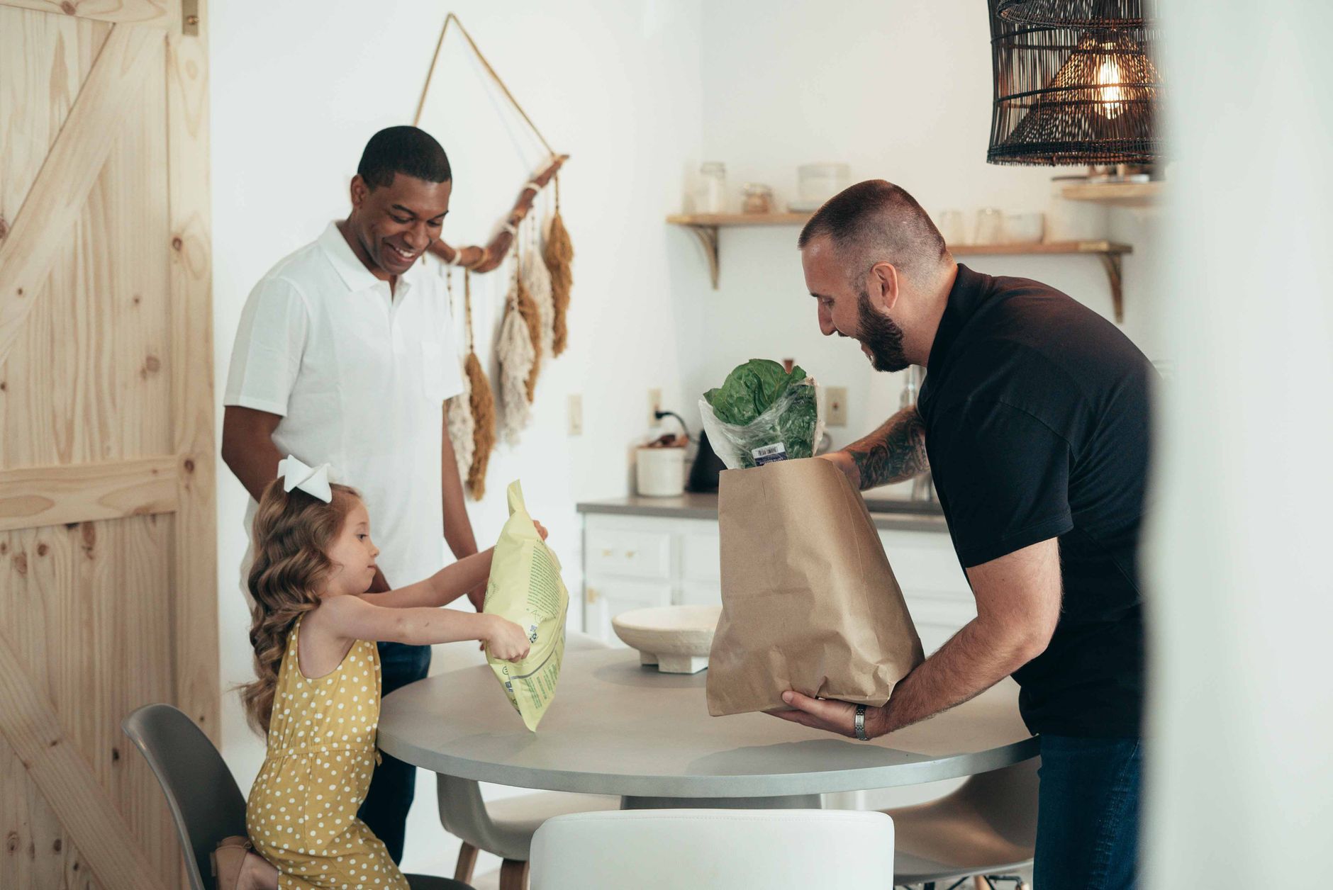 A cheerful family unpacks groceries in a bright, stylish kitchen, fostering joy and togetherness.