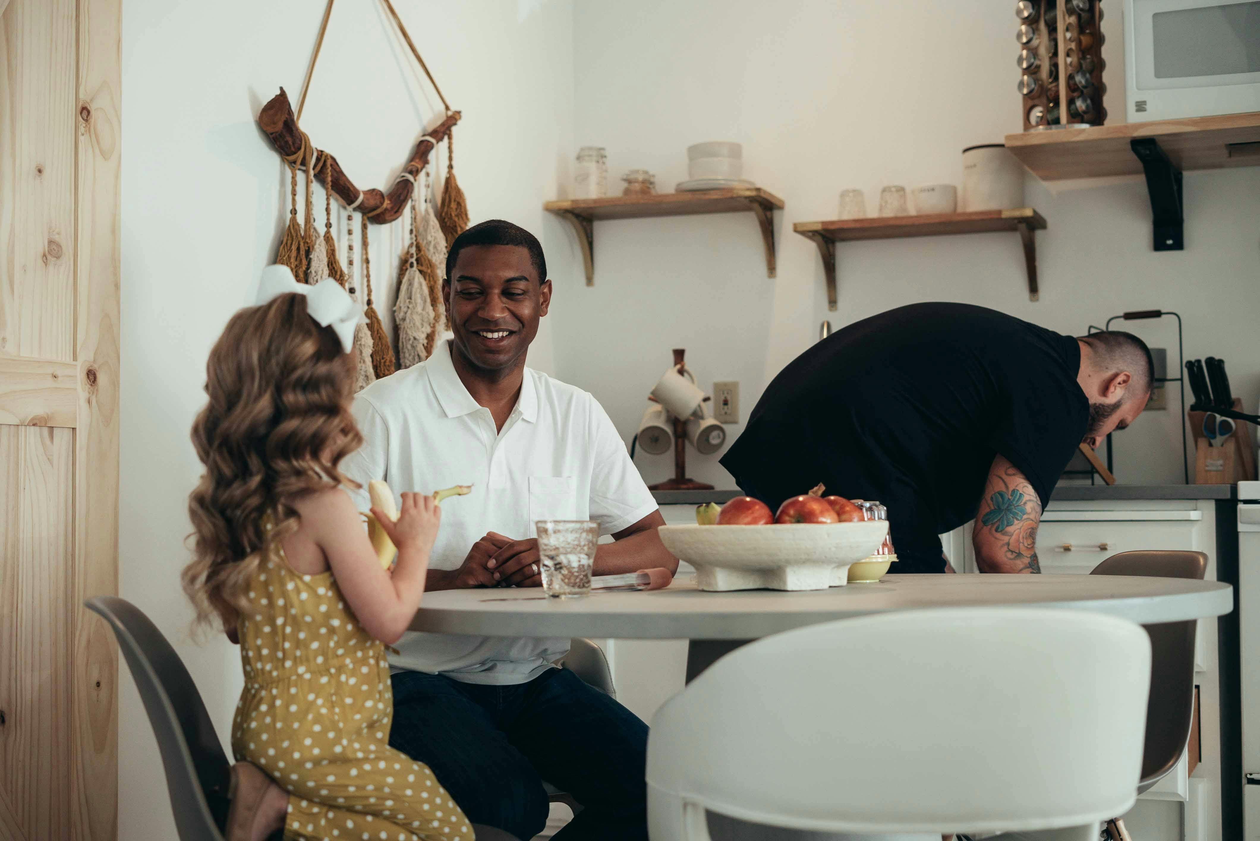 Same Sex Parents and Daughter Having Meal at Kitchen Table · Free Stock  Photo