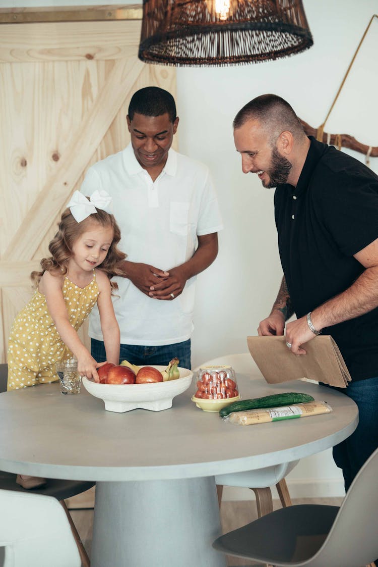 Girl And Men Taking Apples From Table