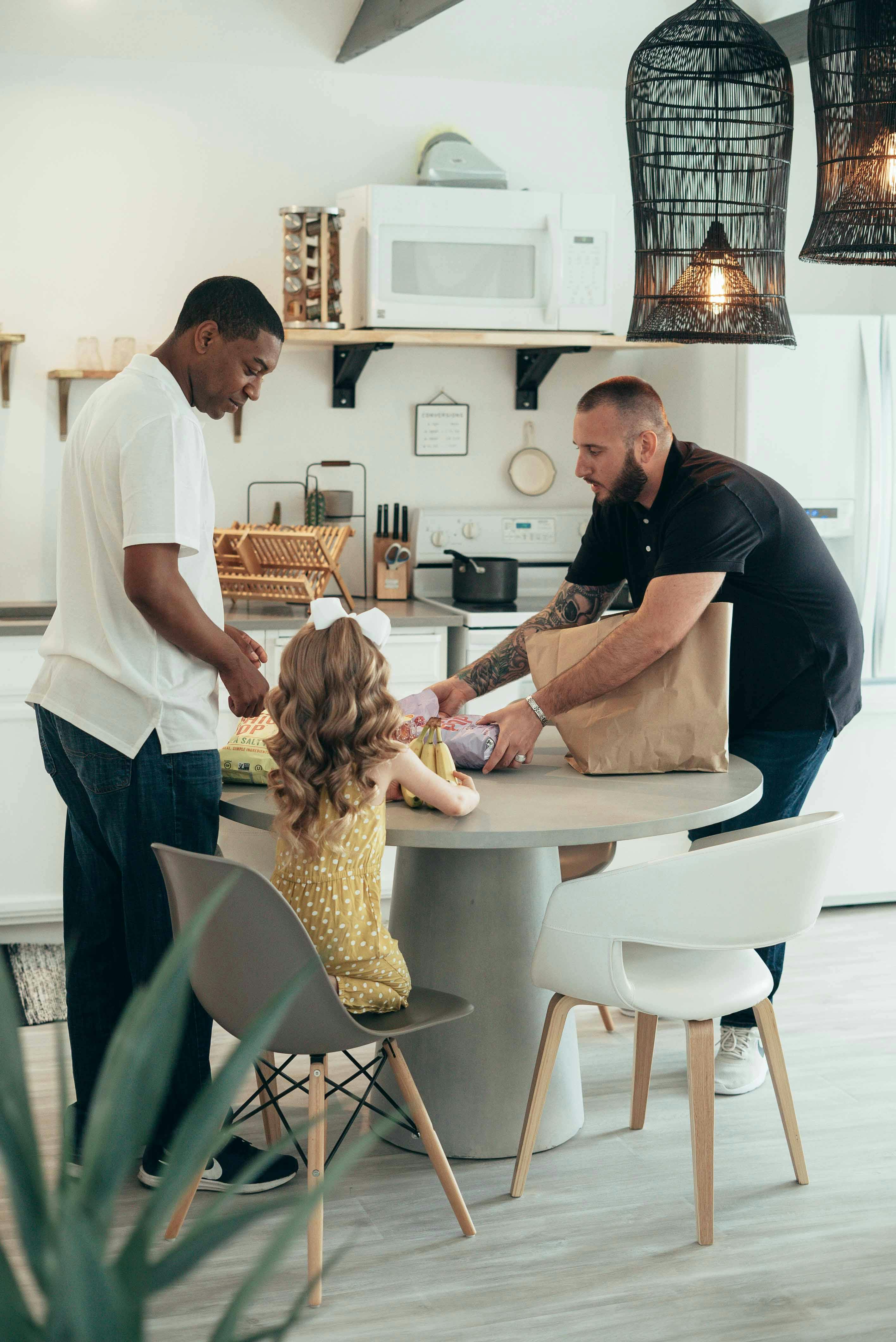 two men and little girl at kitchen table