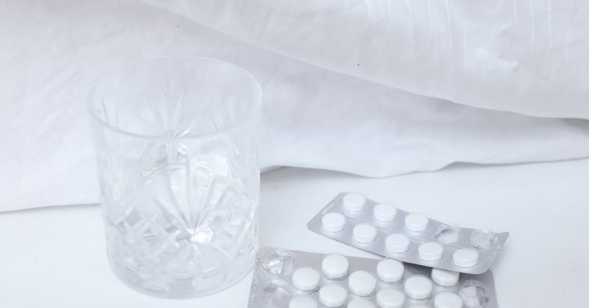 Photograph of a glass near white tablets