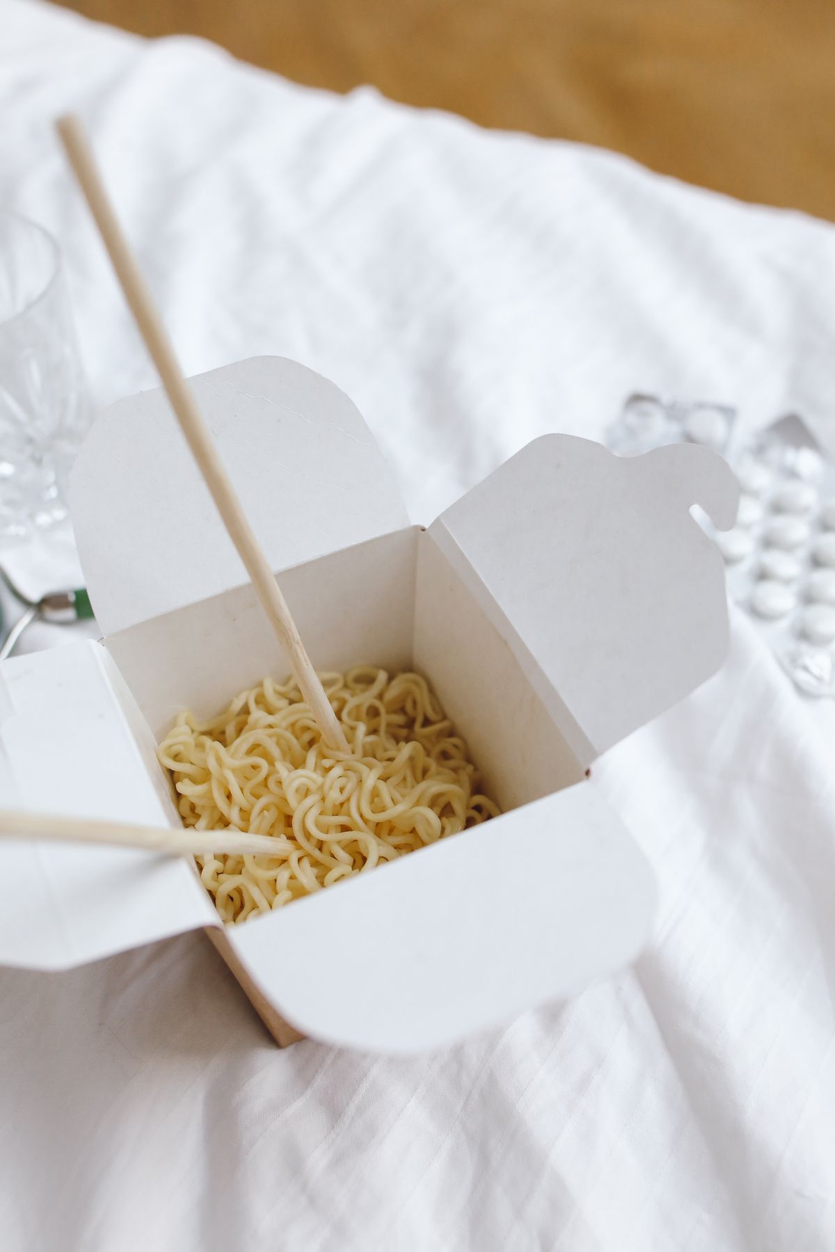 Noodles and chopsticks in an open takeaway box