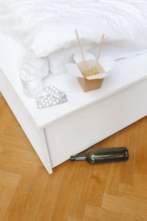 Box of Noodles, Tablets, and a Glass Bottle in a Bedroom