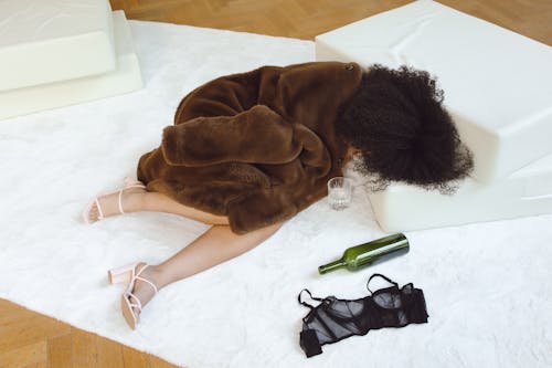 Woman in Brown Fur Sleeping on White Carpet