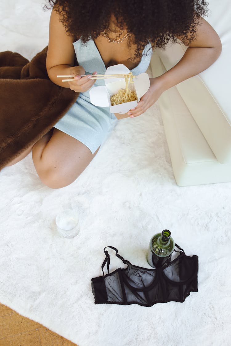 Woman In A Blue Dress Eating A Take Away