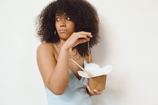 Close-Up Shot of a Curly-Haired Woman Eating Noddles