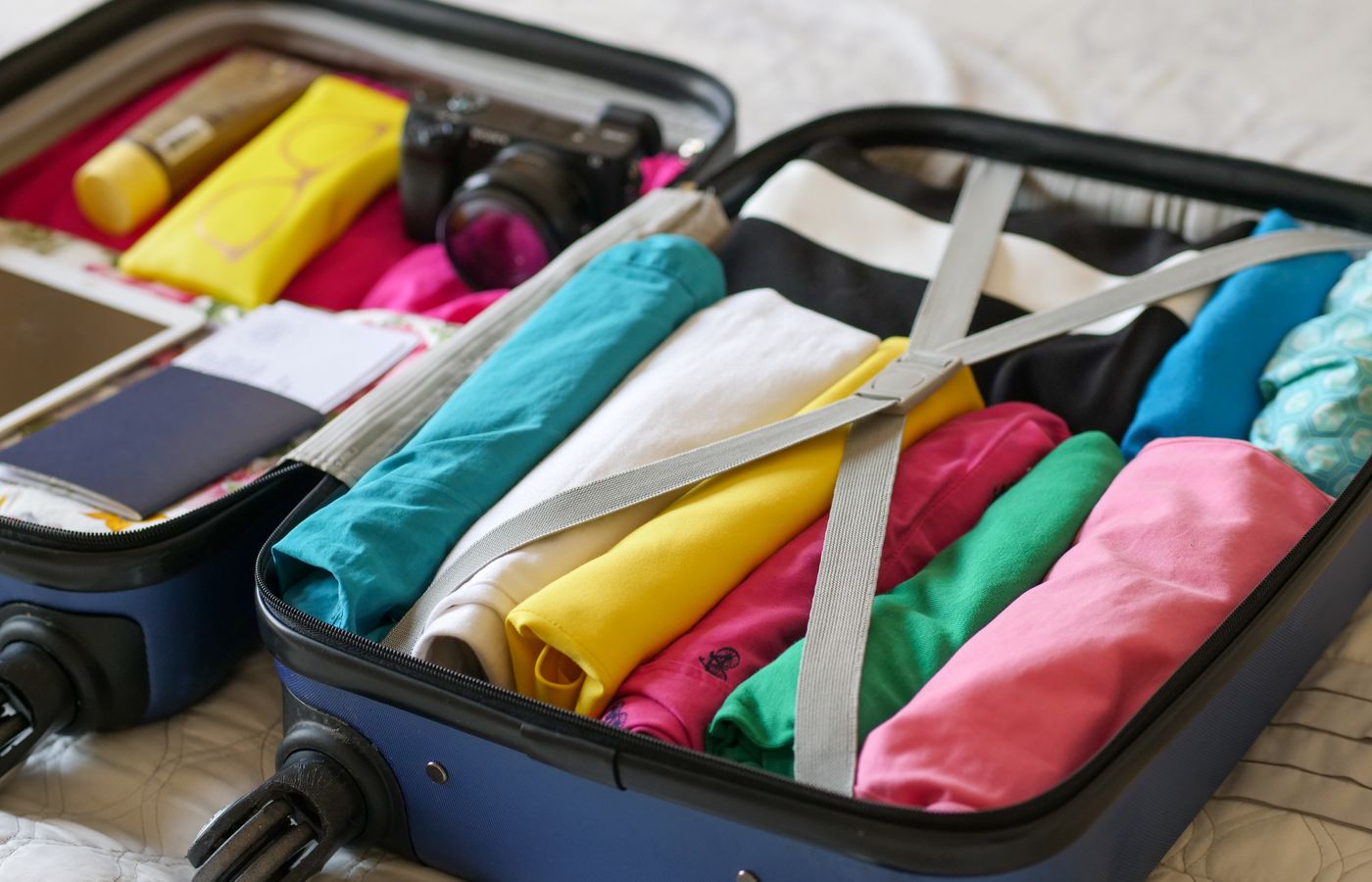 Open suitcase neatly packed with colorful clothes and travel essentials.