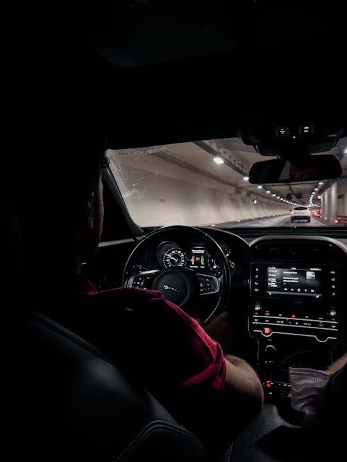 Man In Red Shirt Driving a Car in Tunnel