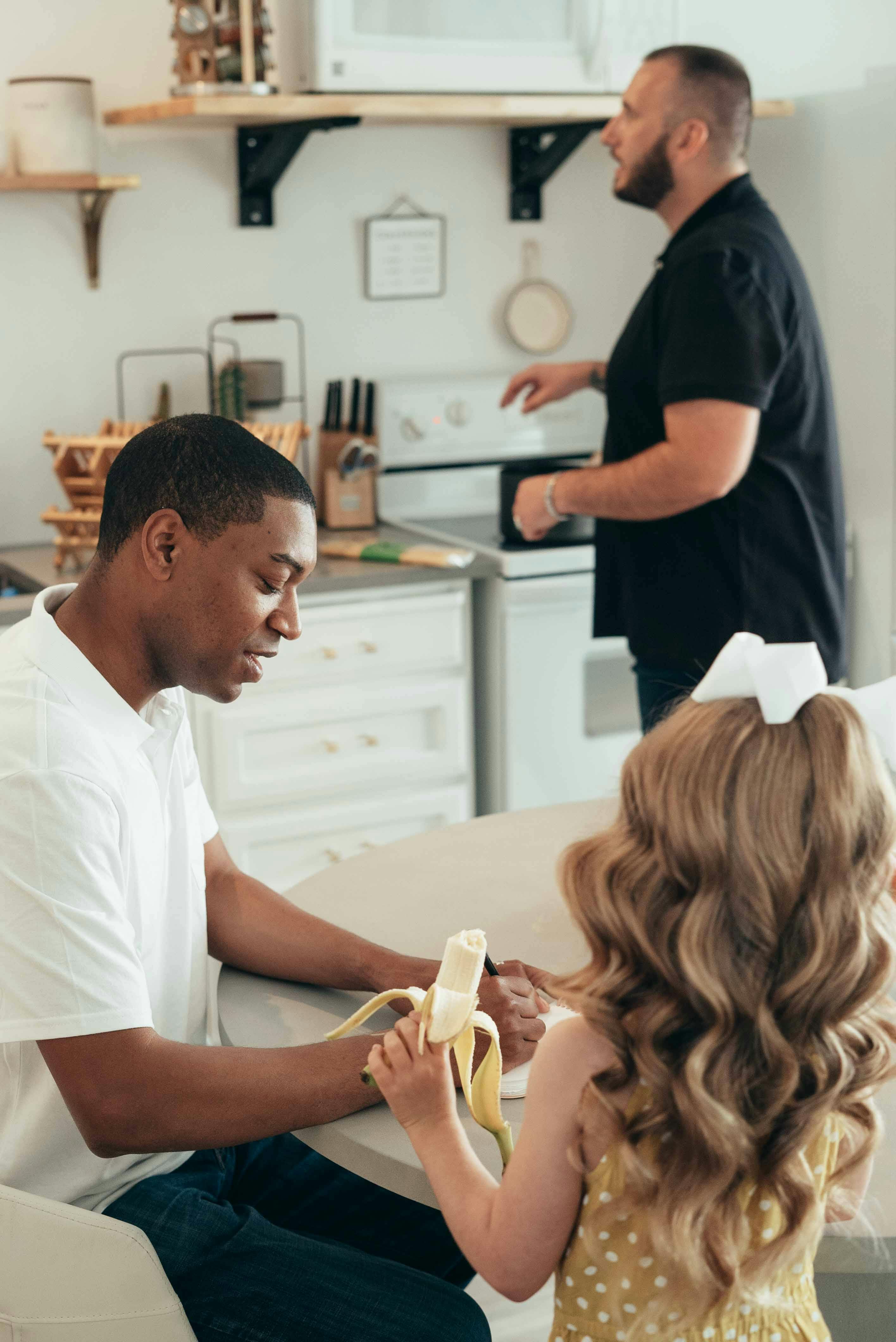 fathers and their daughter in a kitchen during breakfast