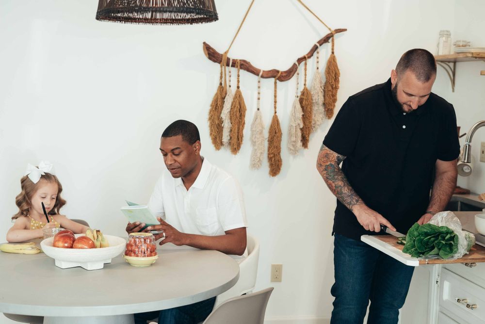 A family sharing a meal together in a warm, modern kitchen.