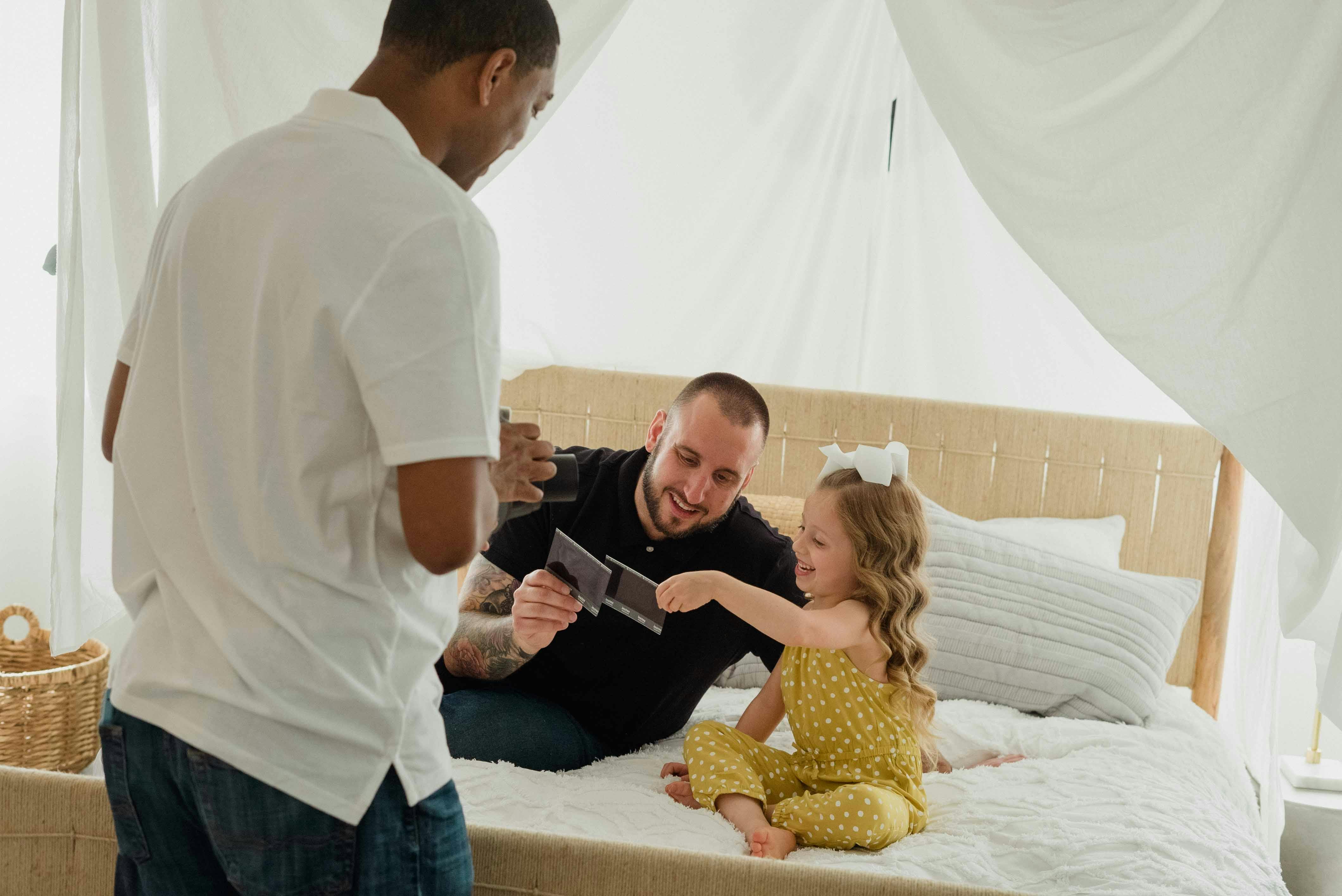 fathers and their daughter looking at pictures and smiling