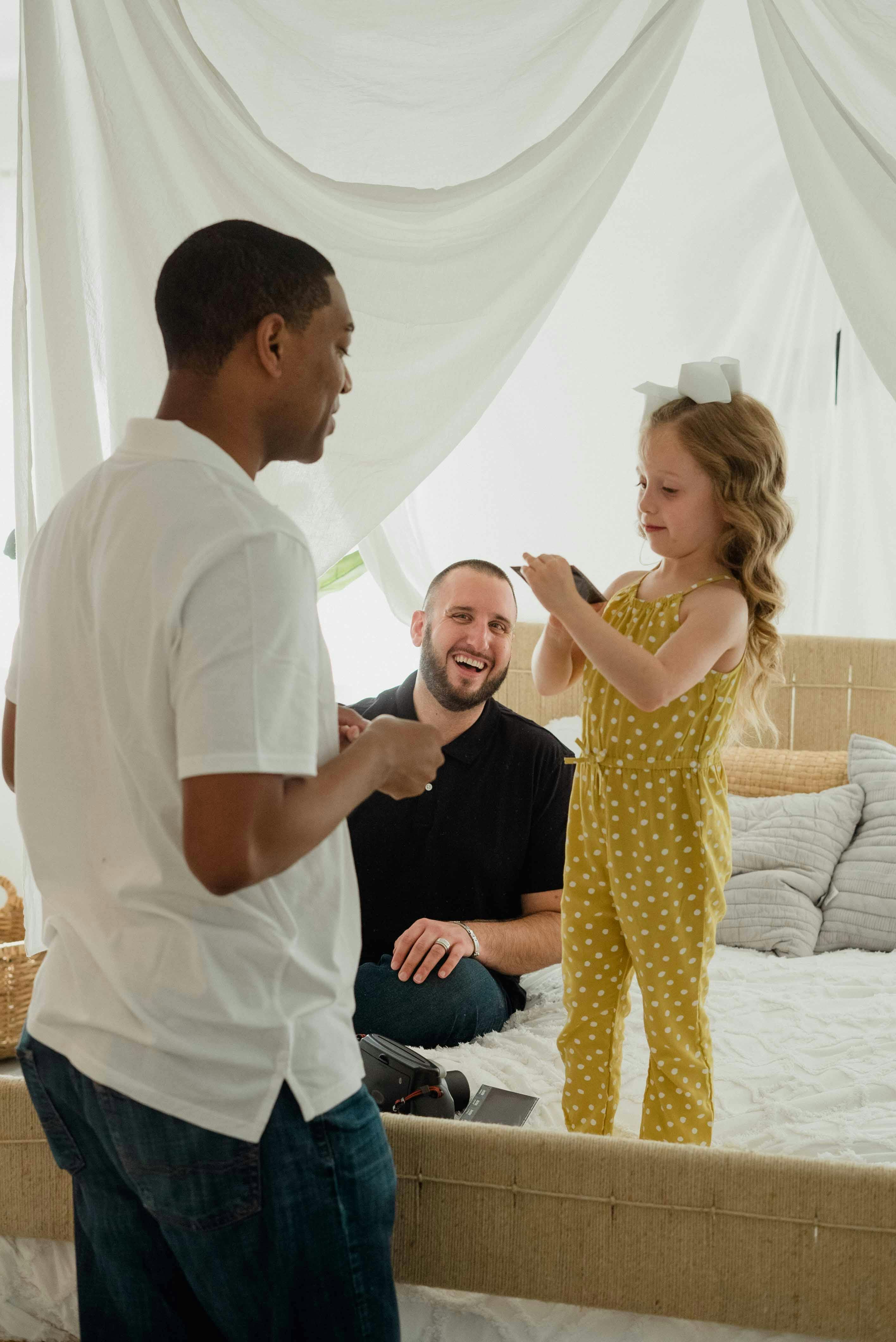 a girl looking at a picture while standing on the bed