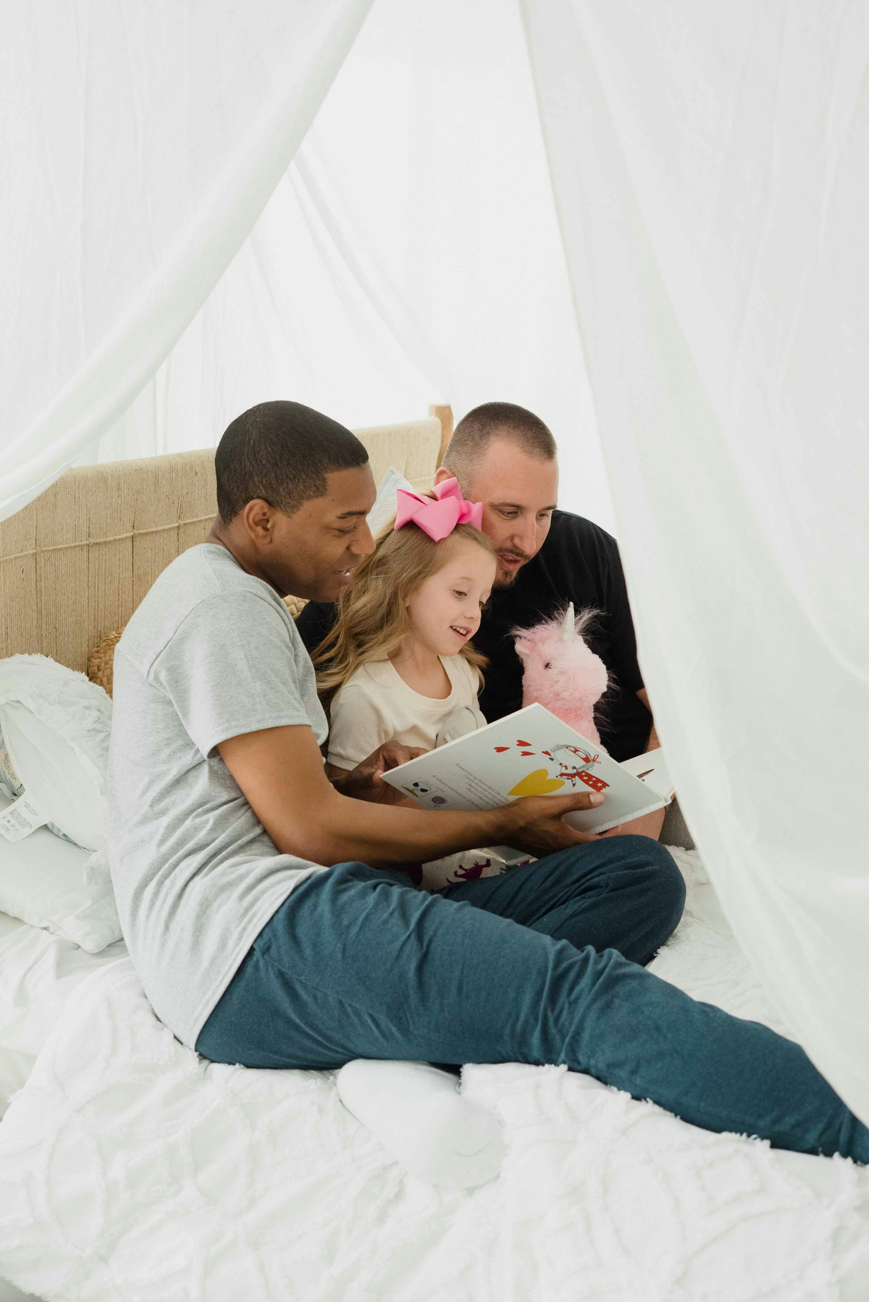 parents reading their daughter a story