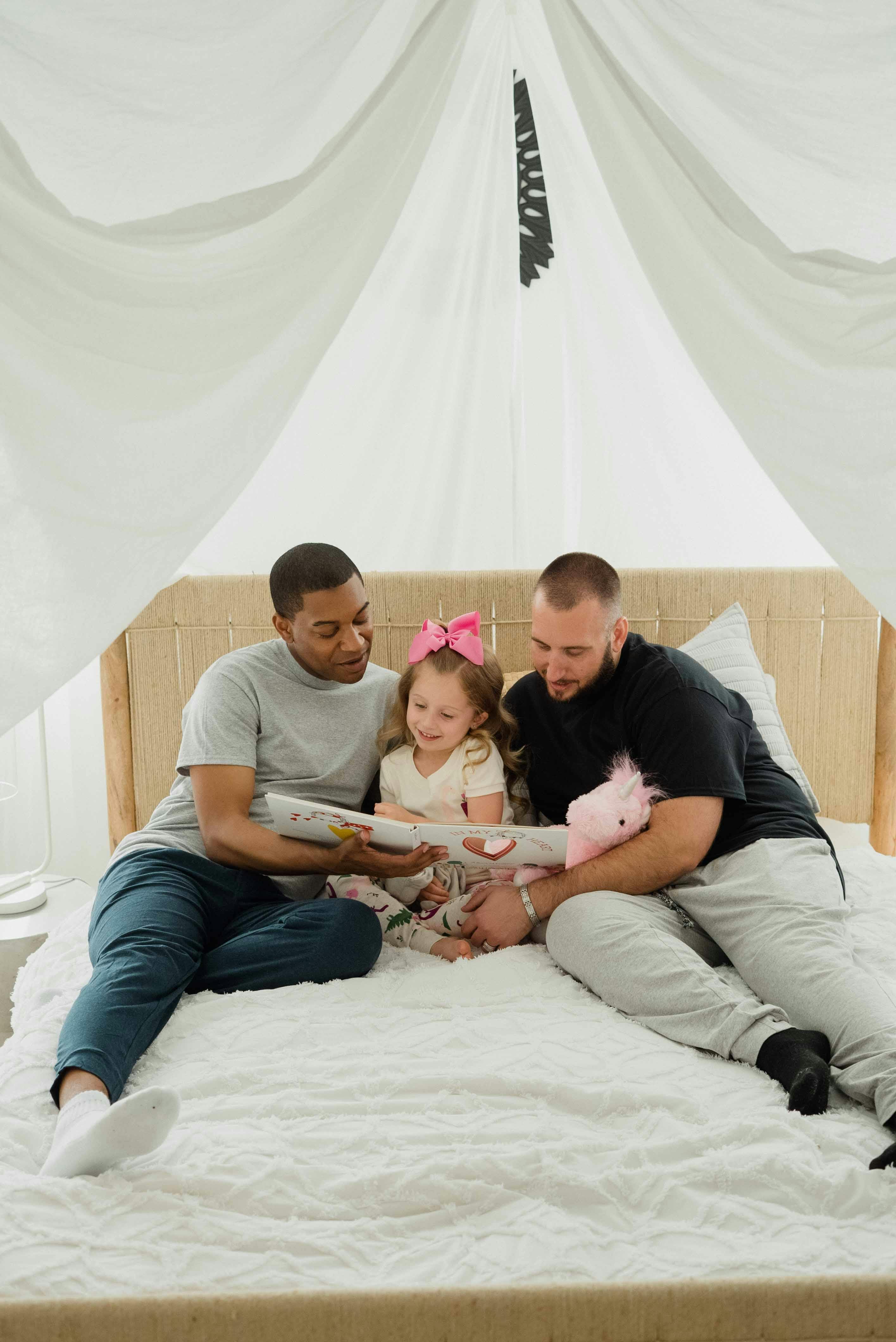 parents reading their daughter a bedtime story