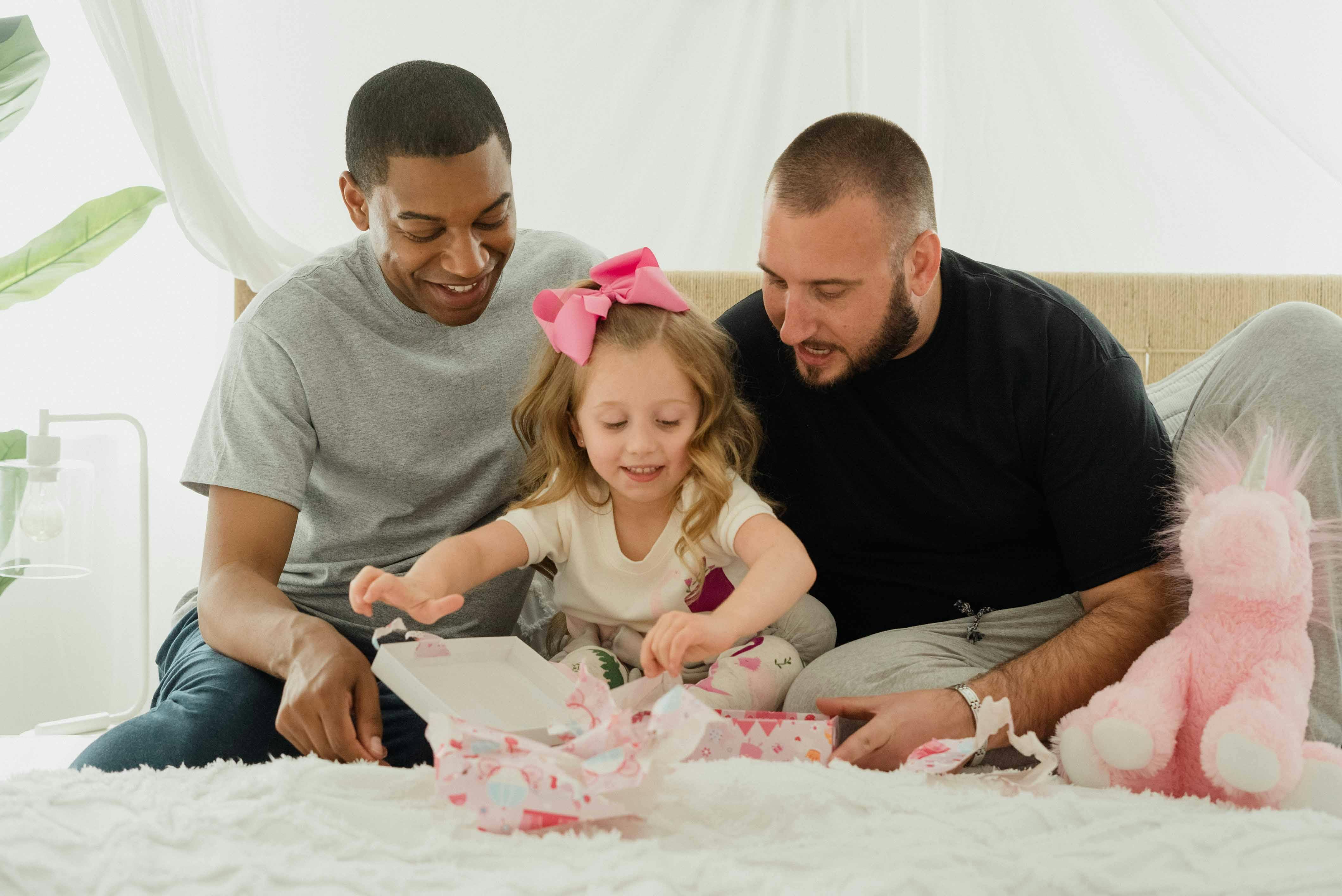 girl and two men unpacking gifts