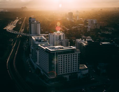 Aerial view of Miami's urban skyline at sunset, featuring traffic and modern buildings.