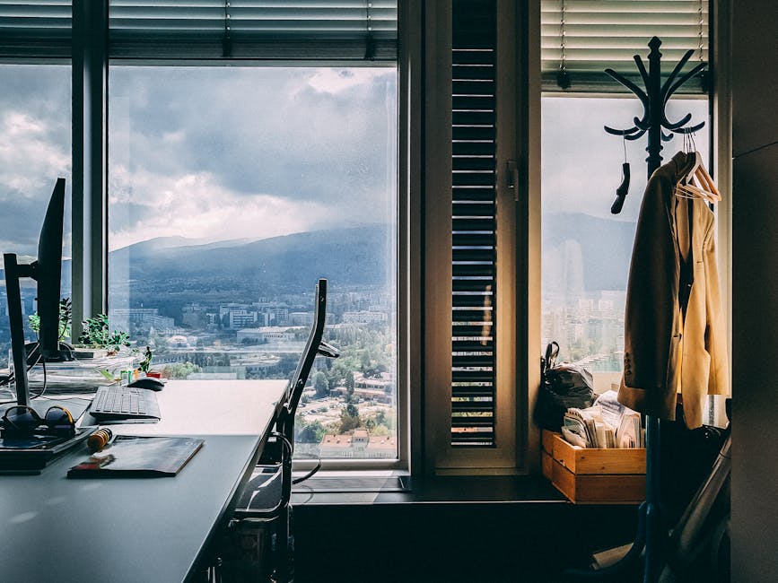 A contemporary office setting with a stunning mountain view through large windows and stylish furnishings.