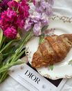 Photograph of a Croissant Near Flowers