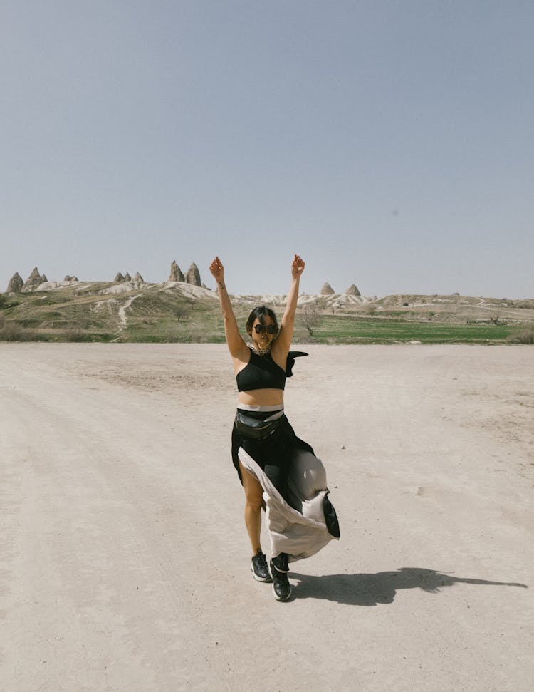 Young Woman Standing With Her Arms In The Air On The Background Of Formations Of Cappadocia, Turkey 