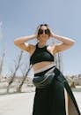 A Woman in Black Crop Top and Black Skirt Posing with Her Hands on Head