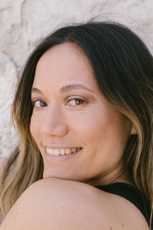 Free Close-up portrait of a smiling woman looking over her shoulder with a blurred background. Stock Photo