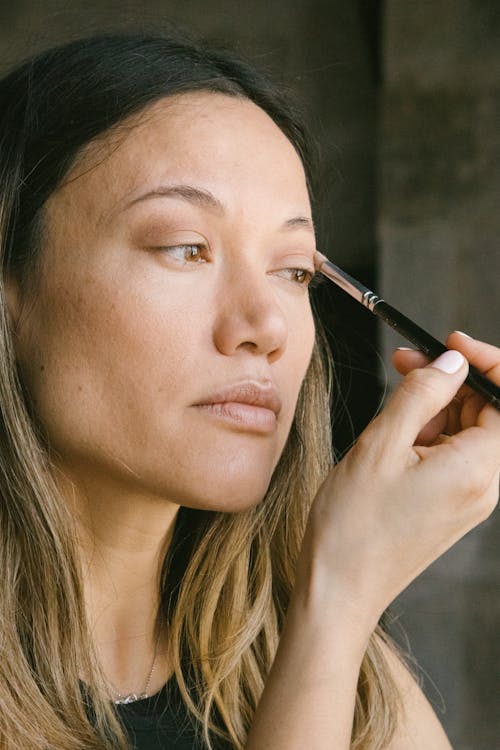 Woman Applying Eye Shadows with Makeup Brush