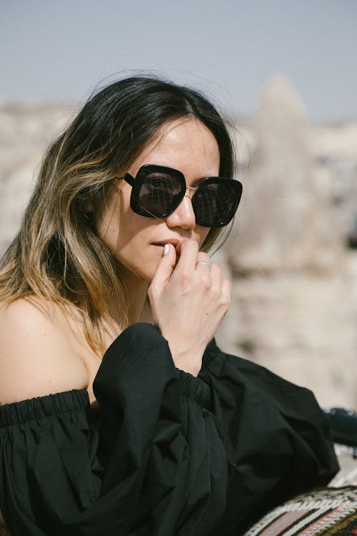 Woman in Black Off Shoulder Top Wearing Black Sunglasses