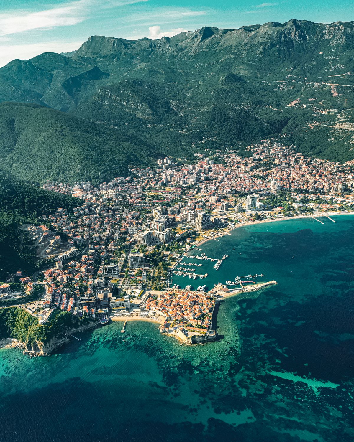 Unde te cazezi în Budva - vedere aeriană a orașului între munți și Marea Adriatică