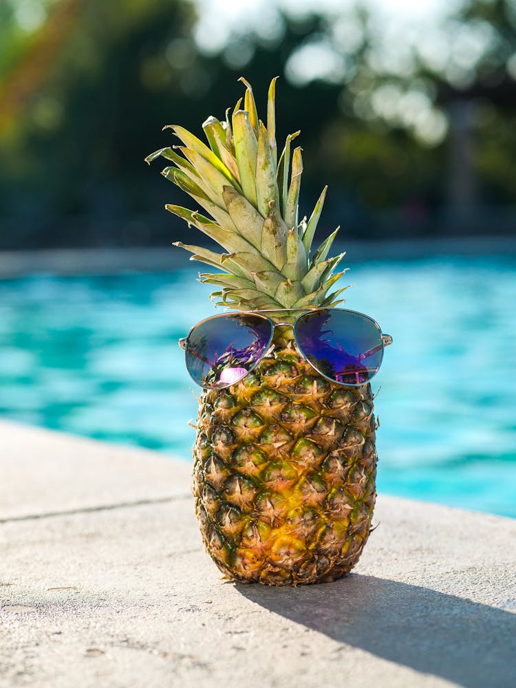 A Pineapple With Sunglasses By The Poolside