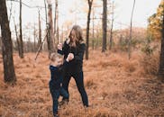 秋天的森林里，一个女人和一个小男孩正欢笑，那是快乐的时刻