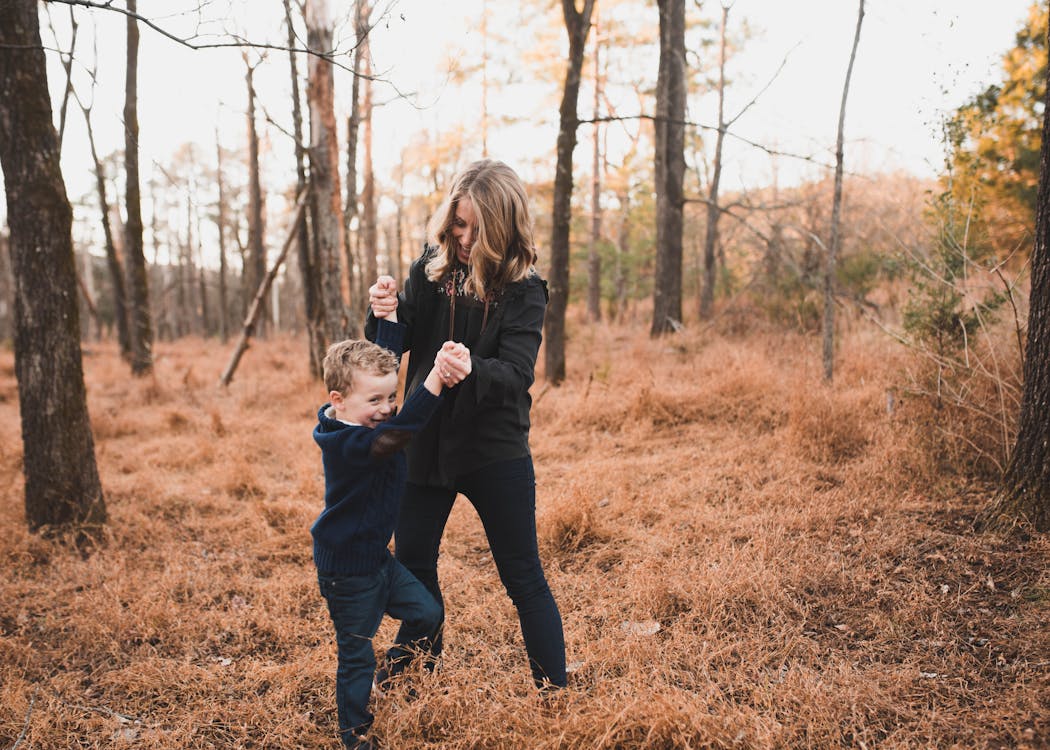 Woman Wearing Black Jacket Playing With Young Boy