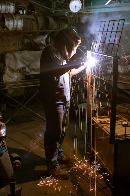 Free Photo of a Man Welding a Metal Frame Stock Photo
