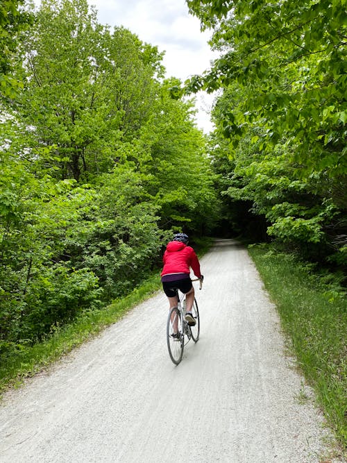 Photo of a Person in a Red Jacket Riding a Bicycle