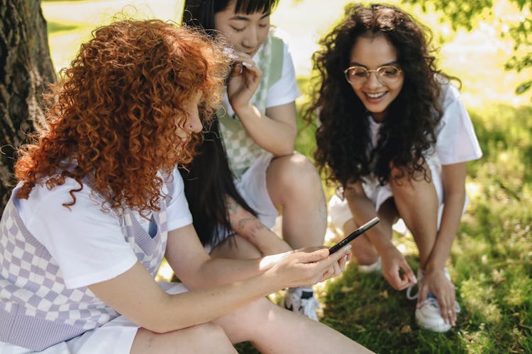 Group Of Students Looking At A Smartphone Together