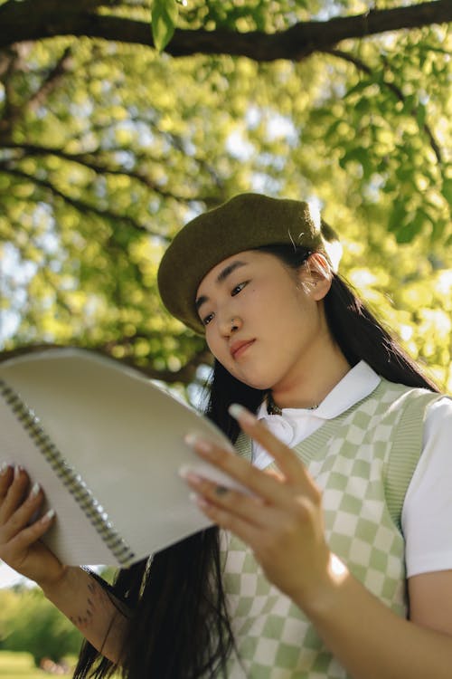 Kostenloses Stock Foto zu asiatische frau, baskenmütze, festhalten